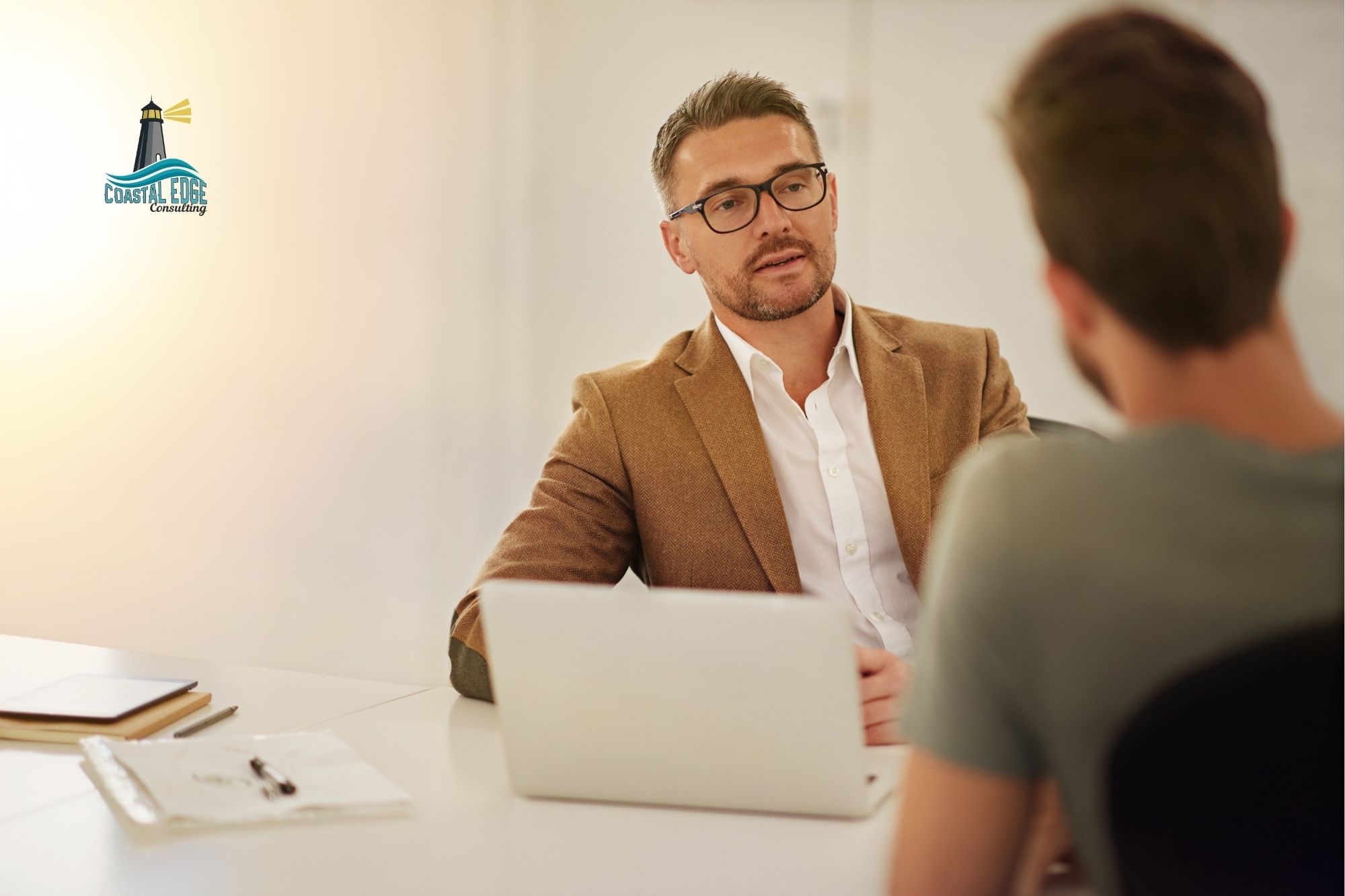 Male leader sitting across from an employee in an office setting